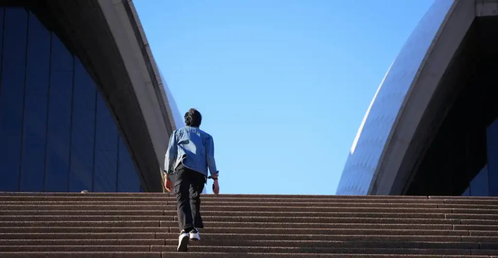 A human silhouette stepping out of a structured framework representing the conscious creator path