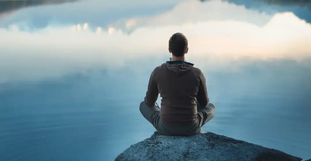 A solitary figure in reflection embodying the practice of sourceful living and conscious awareness